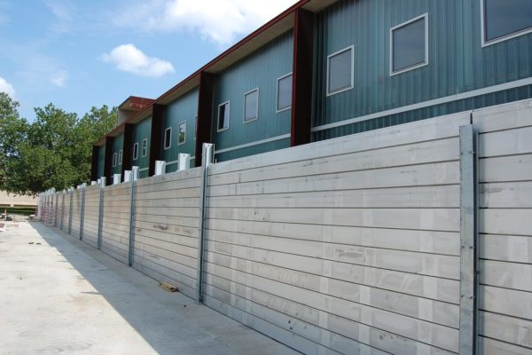 The flood wall spans 300' along the north side of the building. Over 9' high, two intermediate support posts are required along a each 20' plank span to pick up the load of the maximum flood height.