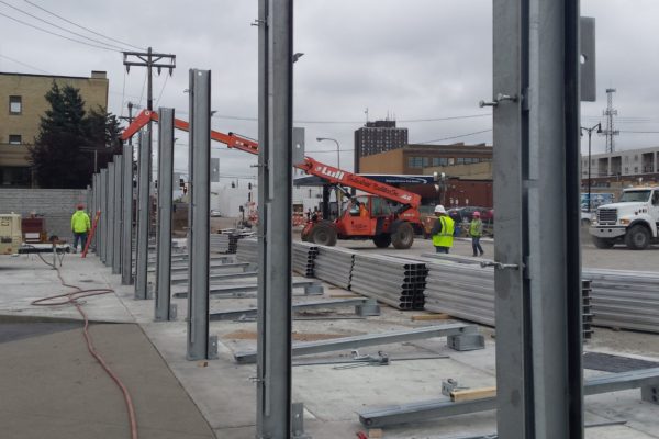 An overhead telehandler can be useful when setting vertical posts above head height. These flood wall posts are over 9-feet high. This configuration uses only parting support posts that are anchored every 10-feet.