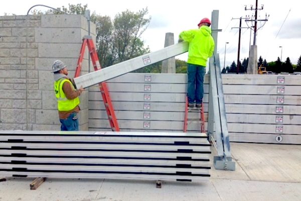 Flood Control America's standard stoplog plank is made of 6000 series extruded aluminum and weigh approximately 5.5 pounds per foot. The planks installed on this project are 10' long and weigh about 55 pounds, an easy lift for two workers.